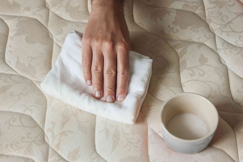 Dùng khăn khô để thấm bớt nước trên nệm